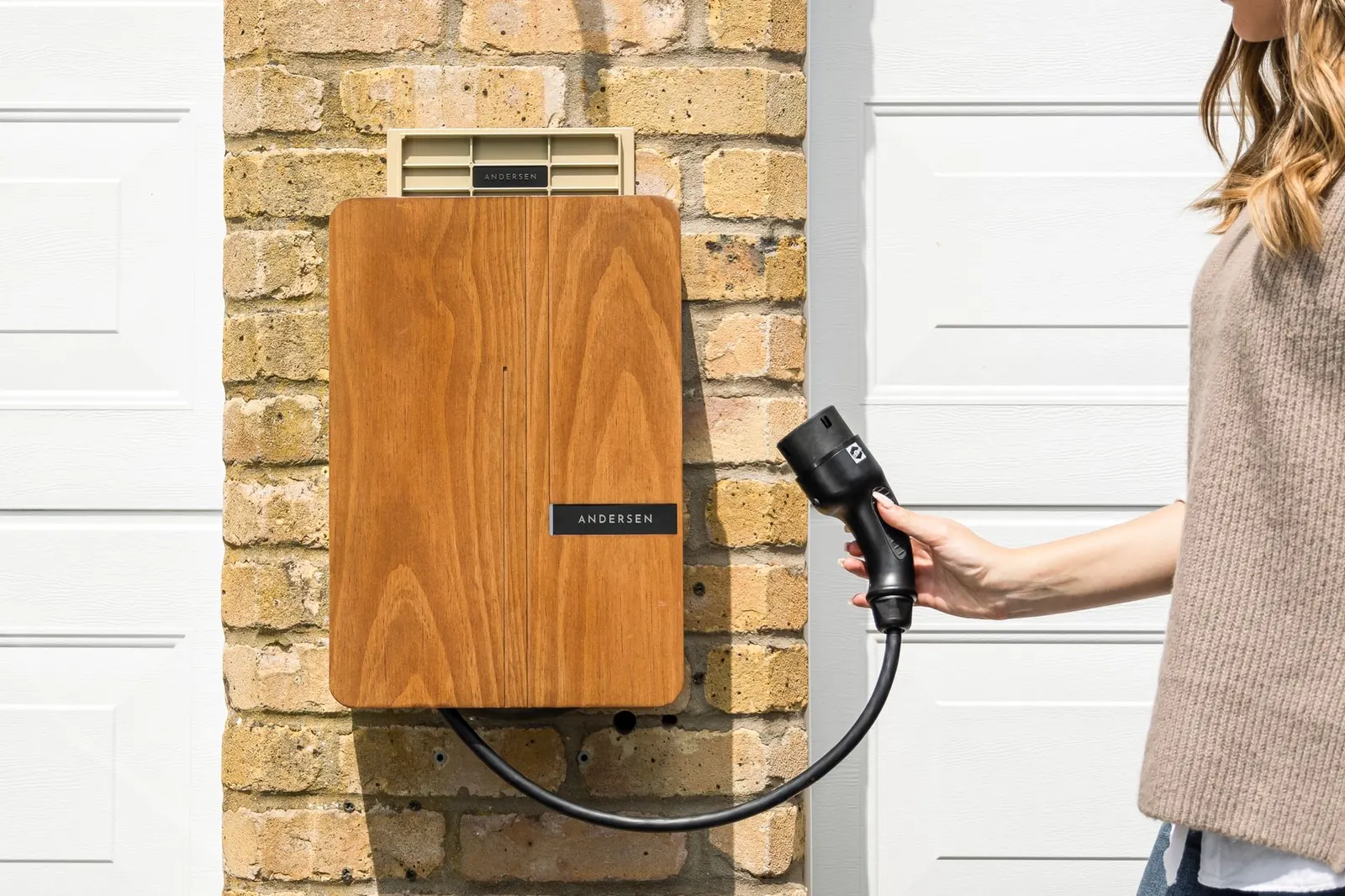 Borne de recharge pour véhicule électrique installée sur le mur d'une maison