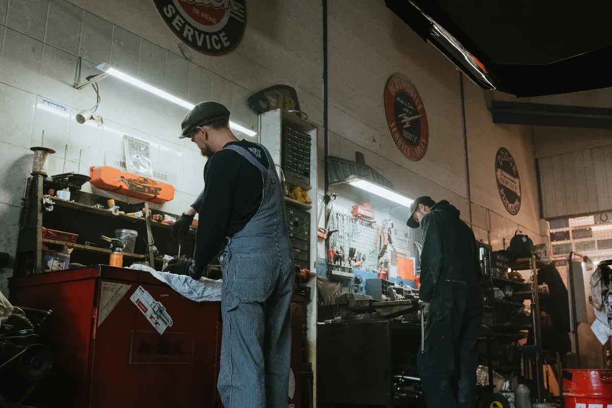 Deux mécaniciens au travail sur une voiture dans l'atelier d'un garage automobile