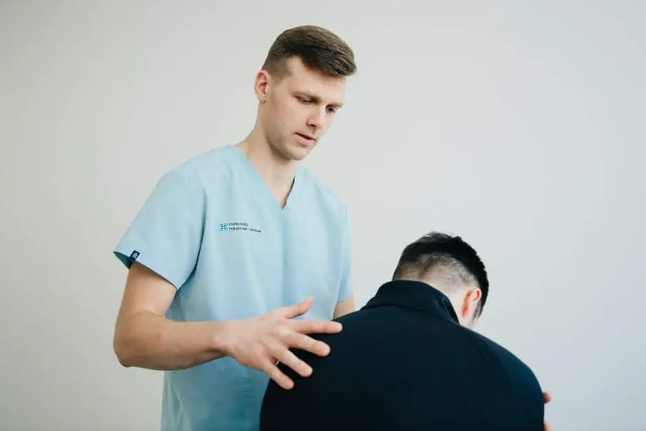 Kinésithérapeute évaluant la posture d'un patient lors d'un bilan